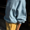 side view of model wearing light blue relaxed fit sweatshirt