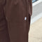 up close of model wearing brown gardners pants with front patches