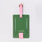 back view of green luggage tag with pink strap and trim with 'miss you already' in cursive
