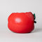 back view of apple ceramic pencil cup laying on its side with 'bite' taken out of the top with 'easy does it' fruit sticker on the side
