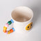 top view of white ceramic mug with rainbow shapes handle and yellow smiley face on the front