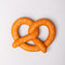 soft pretzel shaped de-stress ball with white heart shaped 'salt' on top laying on a table