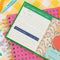 interior of green sticky note folio with white 'sticky notes' on the front with colorful shaped and gold string closure