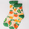 cream chenille socks with green ruffle top with all over veggie print and green grip bottom