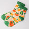 side view of cream chenille socks with green ruffle top with all over veggie print and green grip bottom