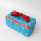 side view of blue quilted zipper makeup bag with red bow handle and all blue floral and bow print