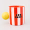 sideview of red and white vertical stripe mug with yellow ball handle and double sided typography with 'BONJOUR!' on one side and 'AU REVOIR' on the other