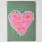 green notebook with pink heart and 'the smell of pastries and books'