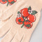 up close of cream gardening gloves with tomato bunches and red trim