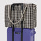 cream and black gingham cloud carry-on on a suitcase