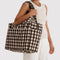 model carrying brown blurred gingham cloud carry-on