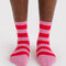 model wearing pink and red stripe crew socks