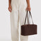 model holding dark brown medium bowler bag