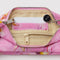 yellow interior of bright pink pochette bag with melting gold star print
