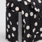 up close of black and white polka dot small cloud carry on bag with laptop in the back