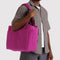 model carrying deep fuchsia small cloud carry on bag