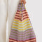 model holding colorful gradient horizontal stripe baggu