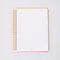 white lined paper inside of white mini notebook with colorful patchwork design (bows, heart, pretzel, strawberry etc)
