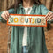model holding colorful rectangle banner with orange trim and 'GO OUTSIDE' in alternating colors