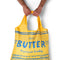 model holding yellow reusable bag with blue butter label