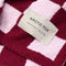 up close of light pink and burgundy checkered blanket