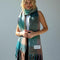 model wearing teal, salmon, green and lilac oversized checker scarf with fringe