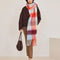 model wearing thick scarf with various shades of blue and red checkers and fringe