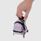 model holding dusty pink mini backpack charm keychain with a key hanging from it