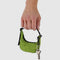 model holding green grass mini crescent bag charm with a key hanging from it