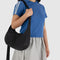 model wearing black medium crescent bag
