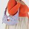 model wearing lavender medium crescent bag with embroidered miffy and white daisy print and matching strap and zipper trim