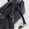 black interior key leash of black small dome recycled leather bowler bag with silver charm clasp