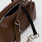 black interior key leash of brown small dome recycled leather bowler bag with silver charm clasp