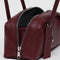 side view of mahogany small dome recycled leather bowler bag with silver charm clasp