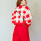 back view of model wearing cropped red, pink and white gingham cardigan with all over embroidered ant print