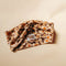 up close of label on brown retro floral twist fabric headband