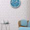 blue wall clock with white trim, numbers, and has retro 50's white and red hands hanging in a vintage inspired lounge