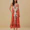 model wearing red, orange and white print maxi dress with ric rac detail and rope straps