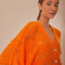 up close of model wearing orange open knit textured cardigan