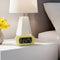 pale yellow digital alarm clock with dark yellow trim on a bedside table