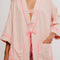 up close of model wearing pink long robe with bright pink trim