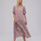 model wearing pink floral drop waist midi dress with periwinkle trim on the neckline and puff sleeves