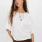model wearing white tee with raw edge detail and bat wing sleeves and brown shorts