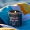 dark blue night swim candle on a beach towel