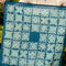 model holding dark and medium blue, cream tiled square bandana