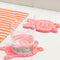 pink tiger coasters with orange face and body outline with a glass of water on one