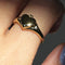 up close of model wearing gold ring with heart shaped locket