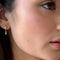 model wearing thick gold figure eight earrings