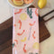 folded light pink cotton tea towel with shrimp cocktail and lemon print