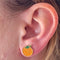 model wearing dainty orange shaped stud enamel earrings